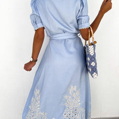 White pastoral style openwork embroidered dress by Christine Brewer, featuring intricate embroidery and a flowing silhouette.