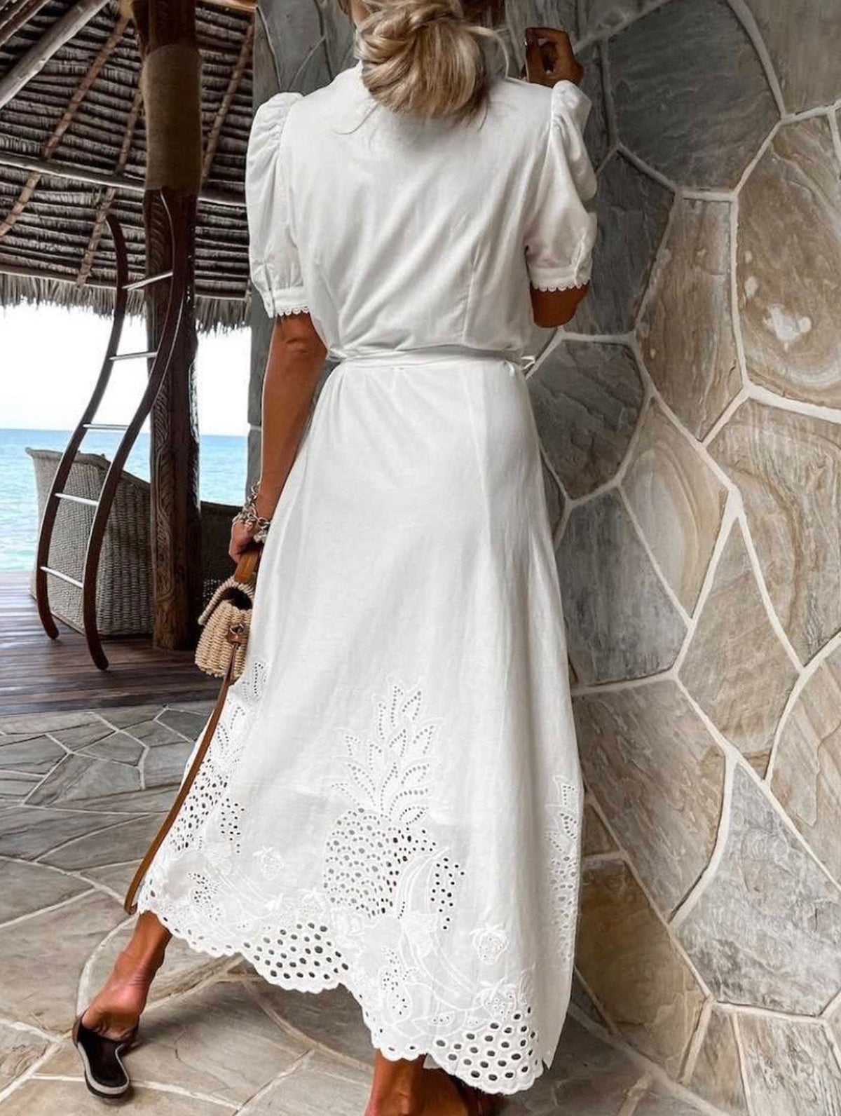 White pastoral style openwork embroidered dress by Christine Brewer, featuring intricate embroidery and flowing fabric.
