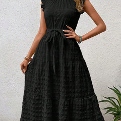 Black ruffled flutter sleeve dress by Christine Brewer featuring tie waist and textured fabric.