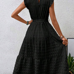 Black textured dress with ruffled flutter sleeves and tie waist by Christine Brewer, featuring a stylish and elegant design.
