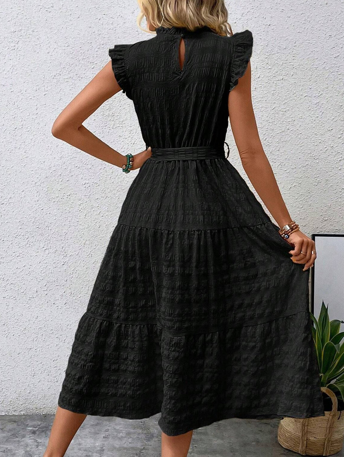 Black textured dress with ruffled flutter sleeves and tie waist by Christine Brewer, featuring a stylish and elegant design.