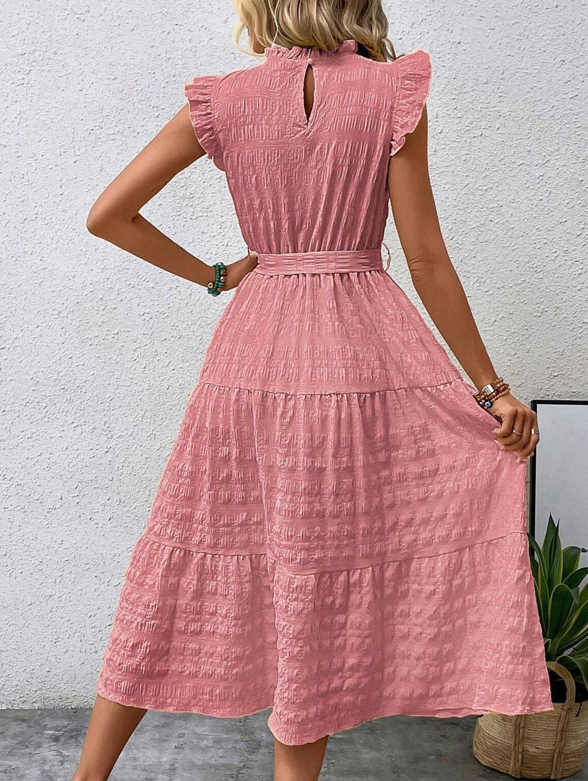 White ruffled flutter sleeve dress by Christine Brewer featuring tie waist and textured fabric, perfect for elegant casual wear.