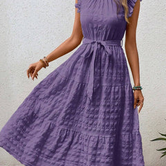 White ruffled flutter sleeve dress by Christine Brewer with tie waist and textured fabric, perfect for casual or semi-formal wear.