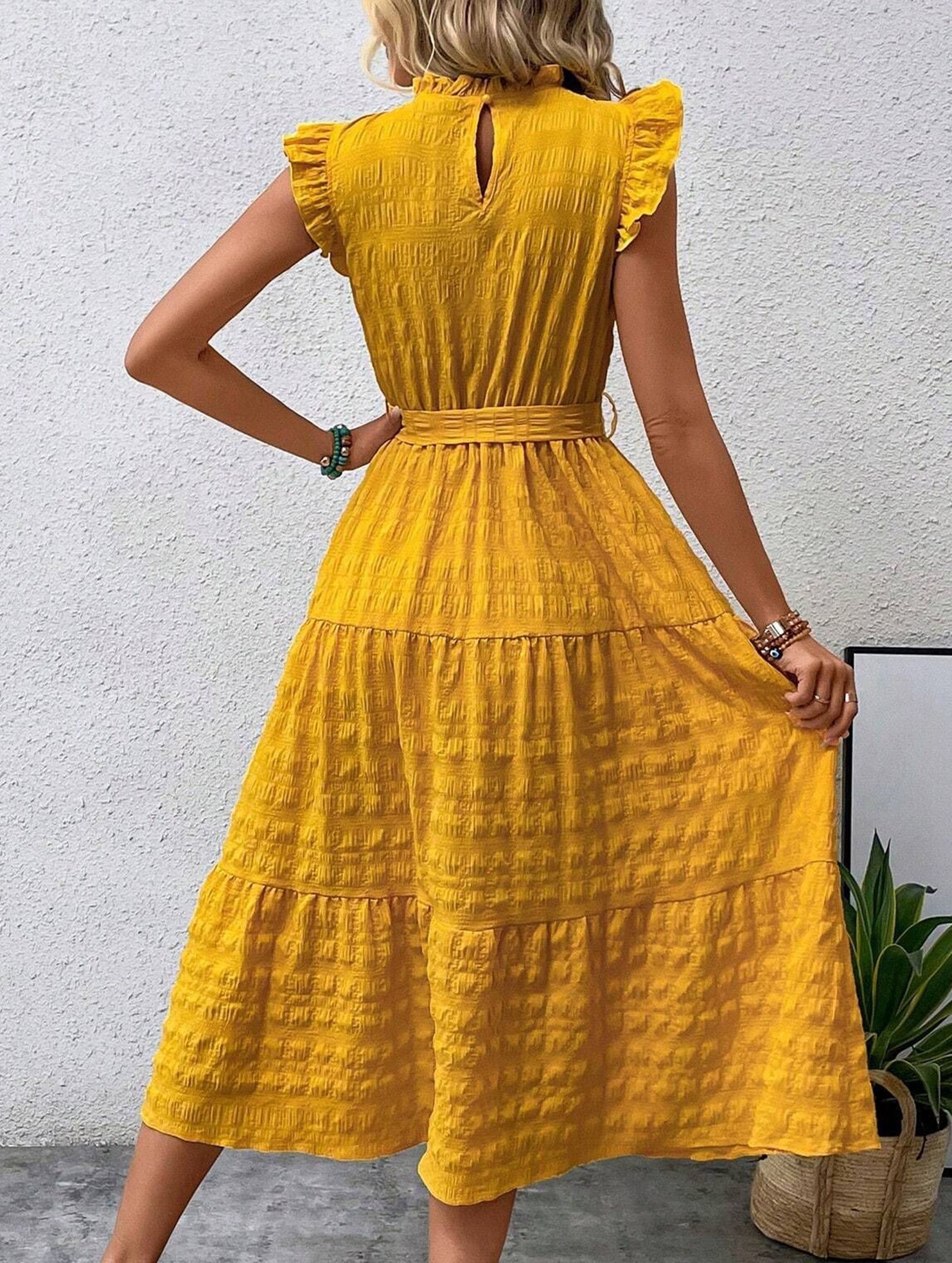 White ruffled flutter sleeve tie textured dress by Christine Brewer, featuring a flowing silhouette and intricate fabric details.
