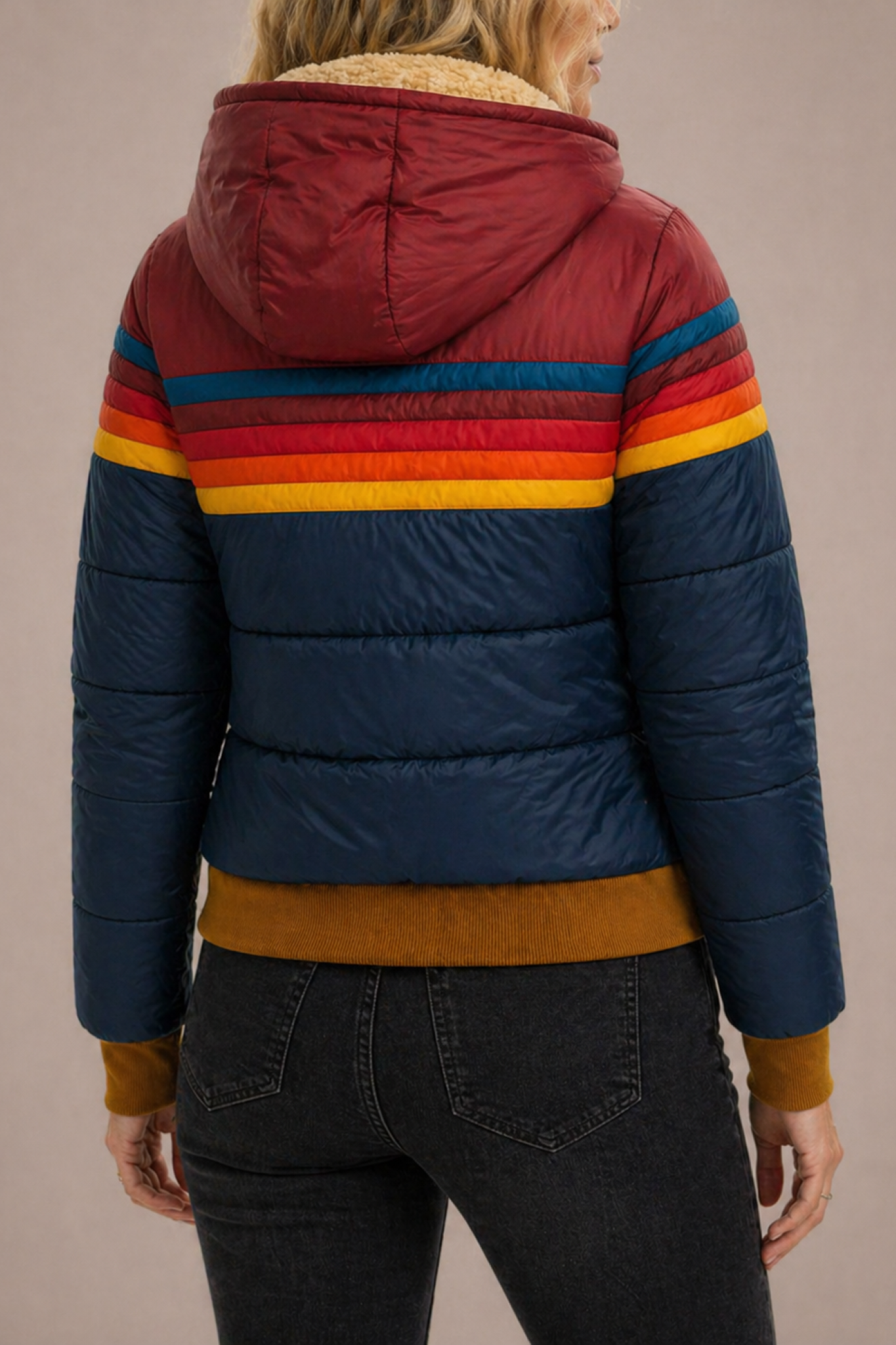 Women’s hooded quilted puffer jacket by Christine Brewer, featuring a stylish, insulated design with a high collar and front zipper.
