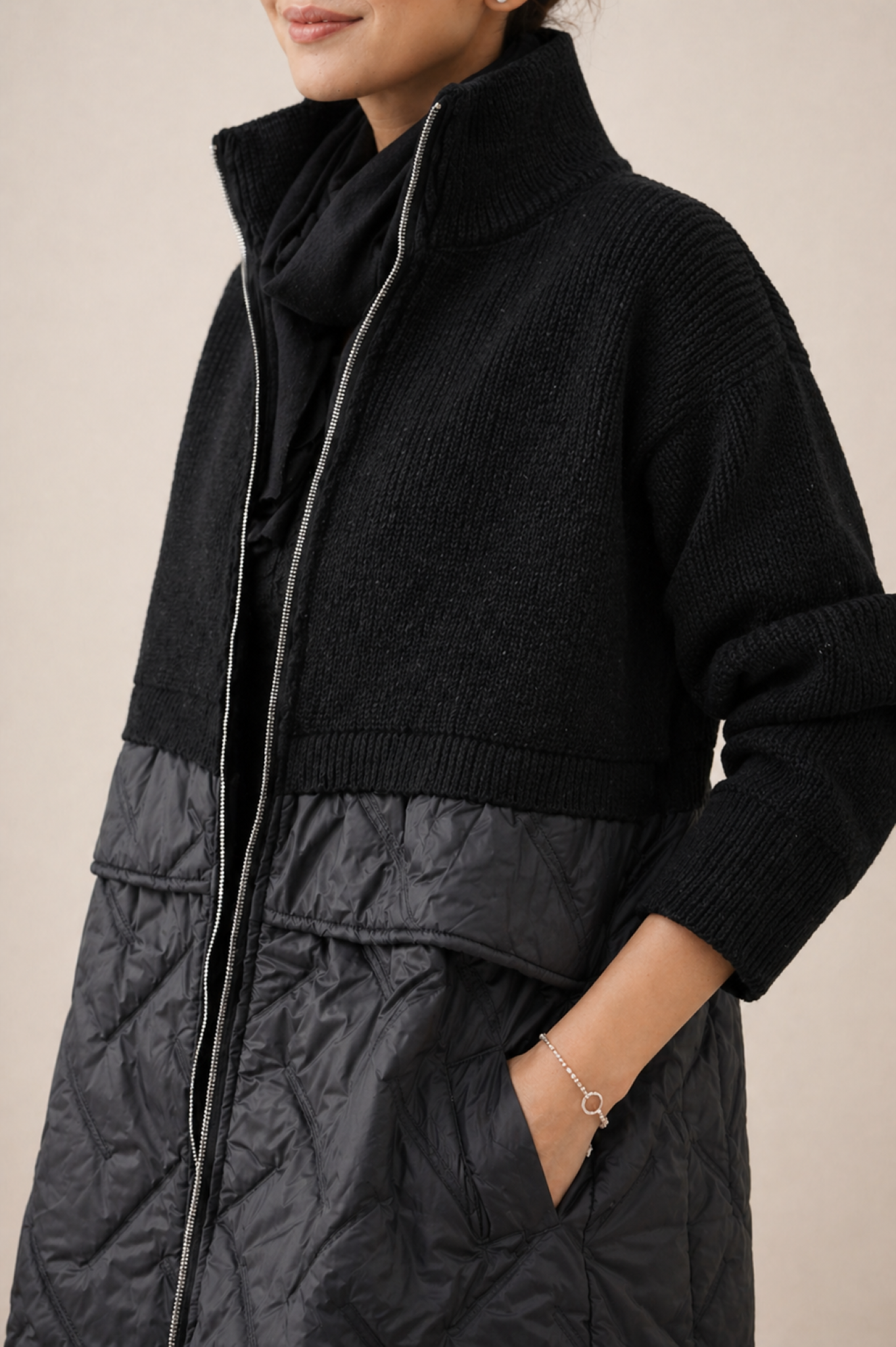 Long quilted puffer jacket for women by Christine Brewer, featuring a stylish, insulated design with a high collar and quilted pattern.