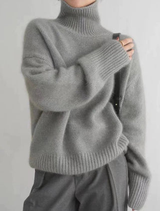 Cream-colored women's turtleneck sweater by Christine Brewer, featuring a cozy, loose-fit wool knit design for fall and winter.