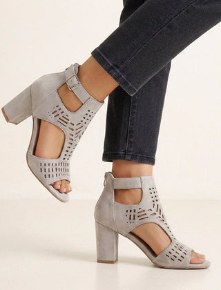Gray women's cut-out block-heel sandals with ankle buckle by Christine Brewer, showcasing stylish open design and ankle strap detail.