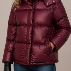 Insulated hooded quilted puffer jacket for women by Christine Brewer, featuring a warm, stylish design with a front zipper and side pockets.