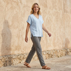 Women’s summer V-neck short sleeve denim blouse by Christine Brewer, styled casually, shown in a lifestyle setting.