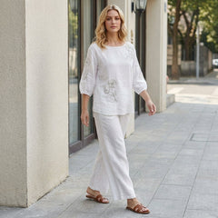 Floral puff sleeve summer blouse for women from Christine Brewer, shown styled with casual accessories in a lifestyle setting.