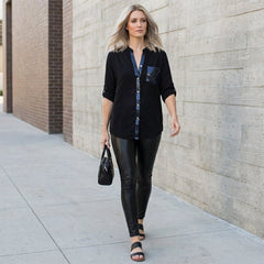 Women’s summer blouse by Christine Brewer featuring a V-neck, denim fabric, and button-front design, styled casually.