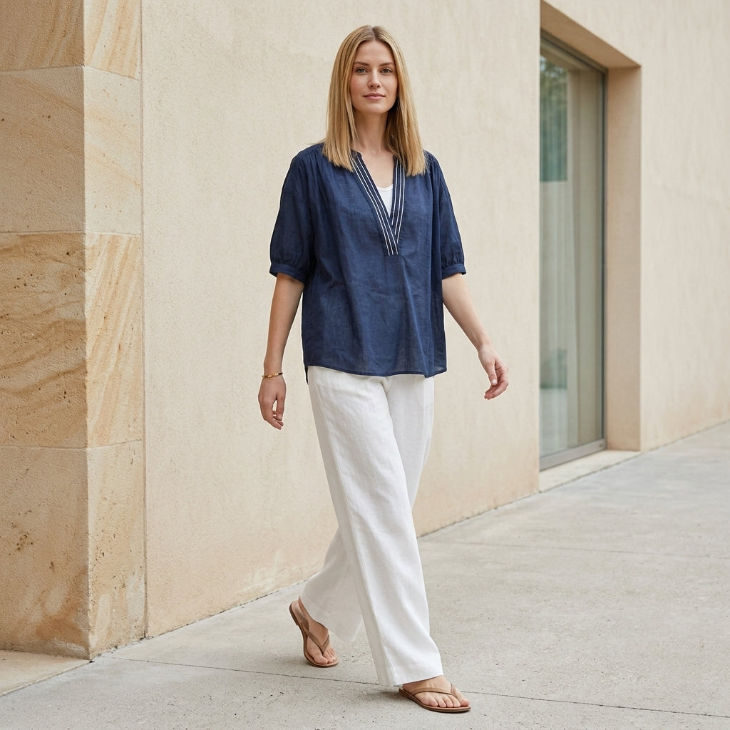 Women's summer blouse by Christine Brewer featuring a V-neck and puff sleeves, styled in a casual outdoor setting.