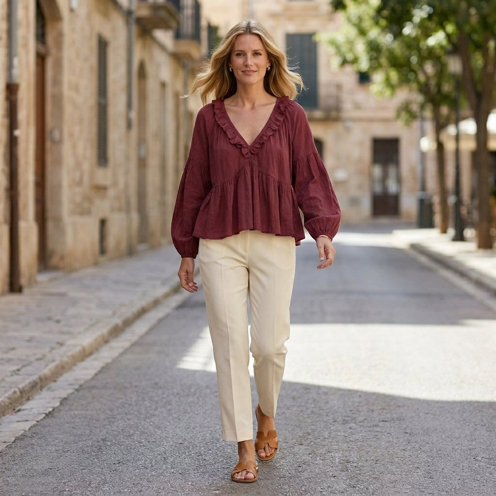 Women’s summer blouse by Christine Brewer featuring a V-neck, long sleeves, and denim fabric with ruffle details.
