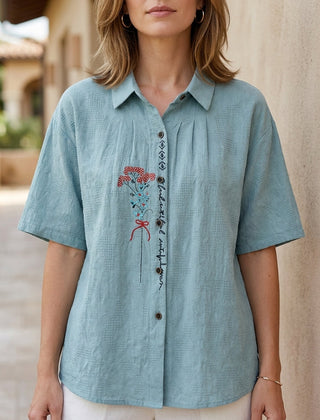 Light blue floral summer blouse for women by Christine Brewer, featuring short sleeves and denim fabric.
