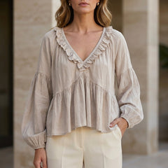Milky white women's summer blouse with V-neck, long sleeves, and ruffle detail, by Christine Brewer, in denim fabric.