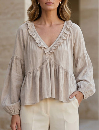 Milky white women's summer blouse with V-neck, long sleeves, and ruffle detail, by Christine Brewer, in denim fabric.