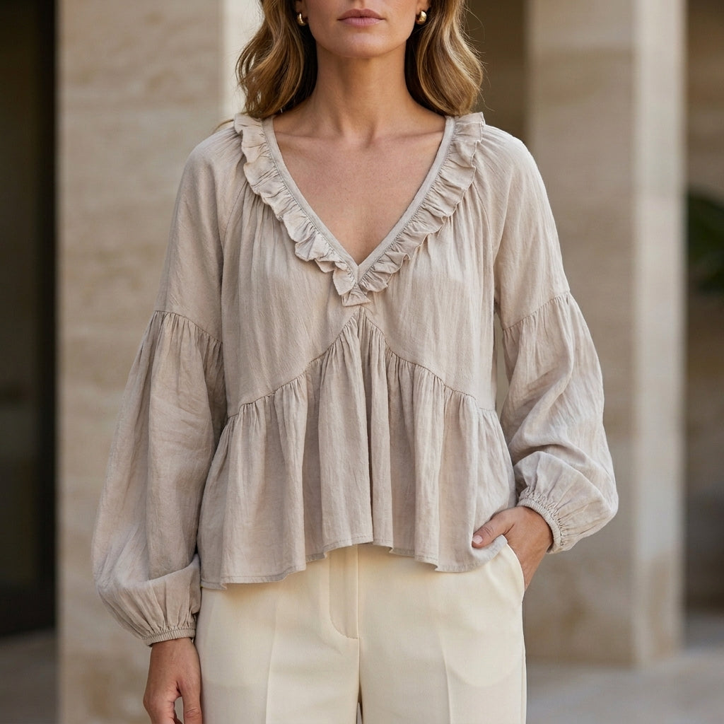 Milky white women's summer blouse with V-neck, long sleeves, and ruffle detail, by Christine Brewer, in denim fabric.