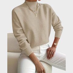 Nienke Huiswerk wearing a cozy, versatile turtleneck sweater by Christine Brewer, featuring a soft knit texture in neutral tones.