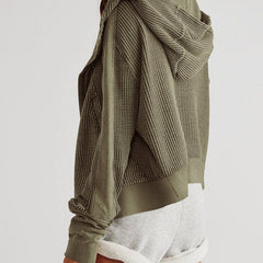 Mia cropped hooded hoodie for women by Christine Brewer, shown in gray with a front pocket and adjustable drawstrings.
