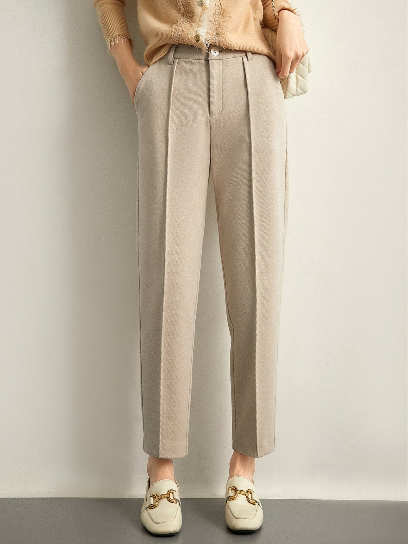 Women's wool tapered trousers by Christine Brewer, cozy merino knit pants with a tailored fit, shown in a neutral color.