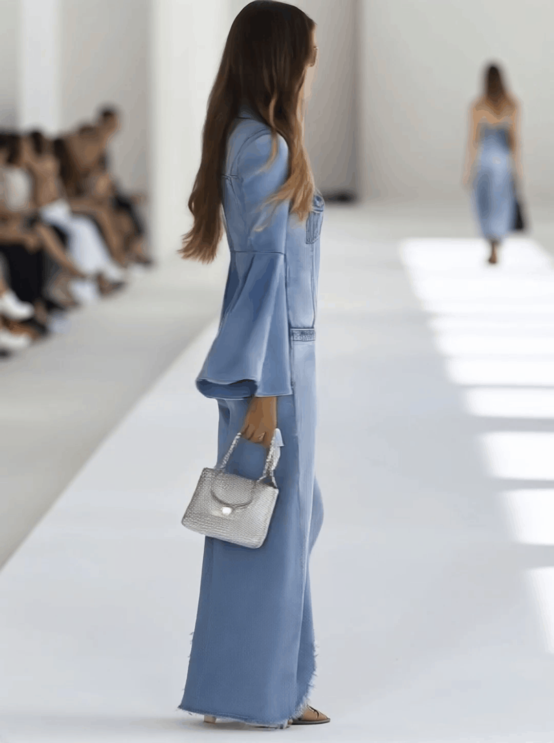 Light blue denim flared long sleeve jumpsuit with wide-leg pants for women by Christine Brewer, shown on a model.