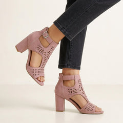 Pink women's block-heel sandals with cut-out design and ankle buckle by Christine Brewer, showcasing stylish open-toe footwear.