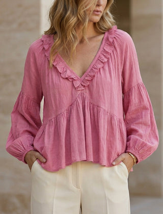 Pink summer women's blouse with V-neck, long sleeves, and ruffle details, by Christine Brewer.