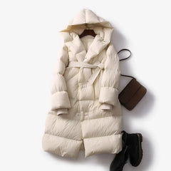 Long belted puffer jacket for women by Christine Brewer, featuring a stylish design and quilted insulation for warmth and comfort.