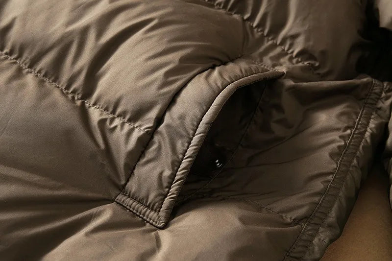 Long hooded parka for women by Christine Brewer, featuring a stylish design with a hood and warm fabric for cold weather.