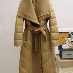 Long belted puffer jacket for women by Christine Brewer, featuring a quilted design and cozy, insulated style.