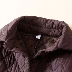 Longline puffer jacket for women by Christine Brewer, featuring a stylish, insulated design with a high collar and quilted texture.