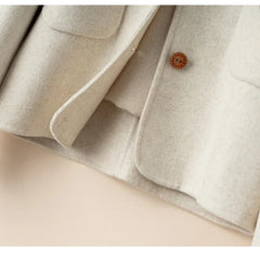 Elegant wool coat for women by Christine Brewer, featuring a tailored design and stylish silhouette in neutral tones.