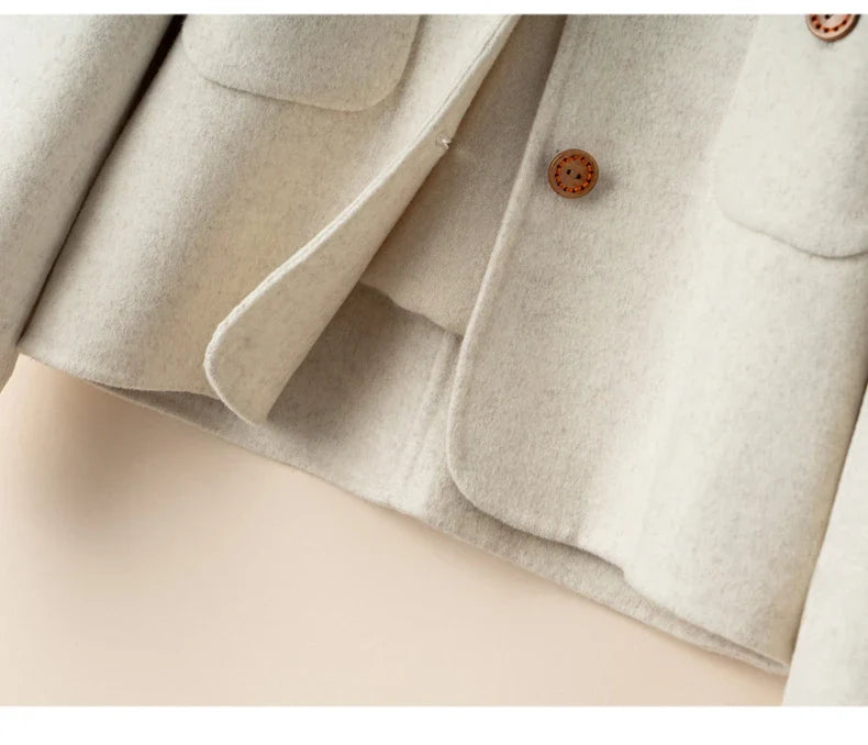 Elegant wool coat for women by Christine Brewer, featuring a tailored design and stylish silhouette in neutral tones.