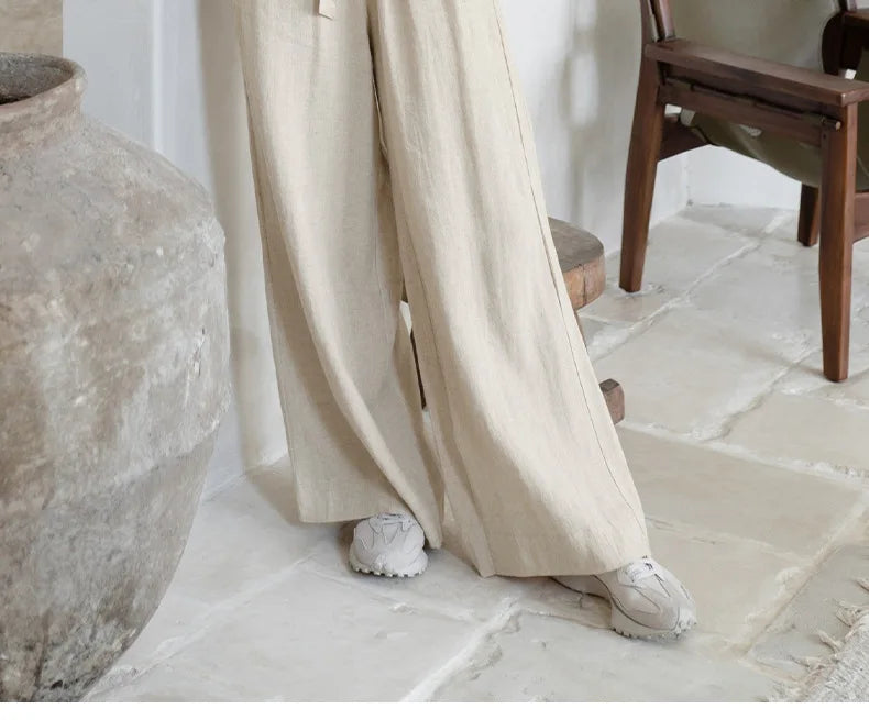 Light beige linen wide-leg trousers for women by Christine Brewer, loose pull-on style with a relaxed fit.