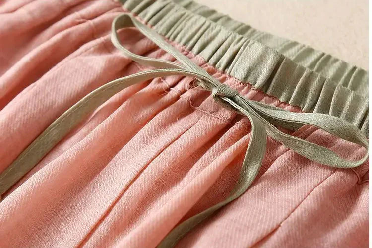Loose tapered linen trousers for women by Christine Brewer, featuring a relaxed fit and pull-on style in natural linen fabric.