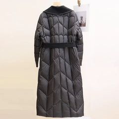 Christine Brewer Lily long belted puffer jacket for women, featuring a stylish quilted design and a waist belt for a flattering fit.