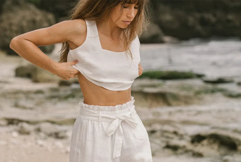 Women’s linen wide-leg trousers by Christine Brewer featuring loose fit and pull-on design, shown in a relaxed, stylish pose.