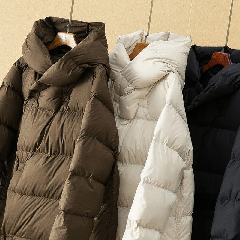 Long hooded women's parka by Christine Brewer featuring a stylish design and a cozy hood for cold weather.
