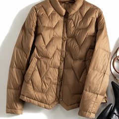 Light pink Aurora short quilted puffer jacket for women by Christine Brewer, featuring a sleek, padded design and stand-up collar.