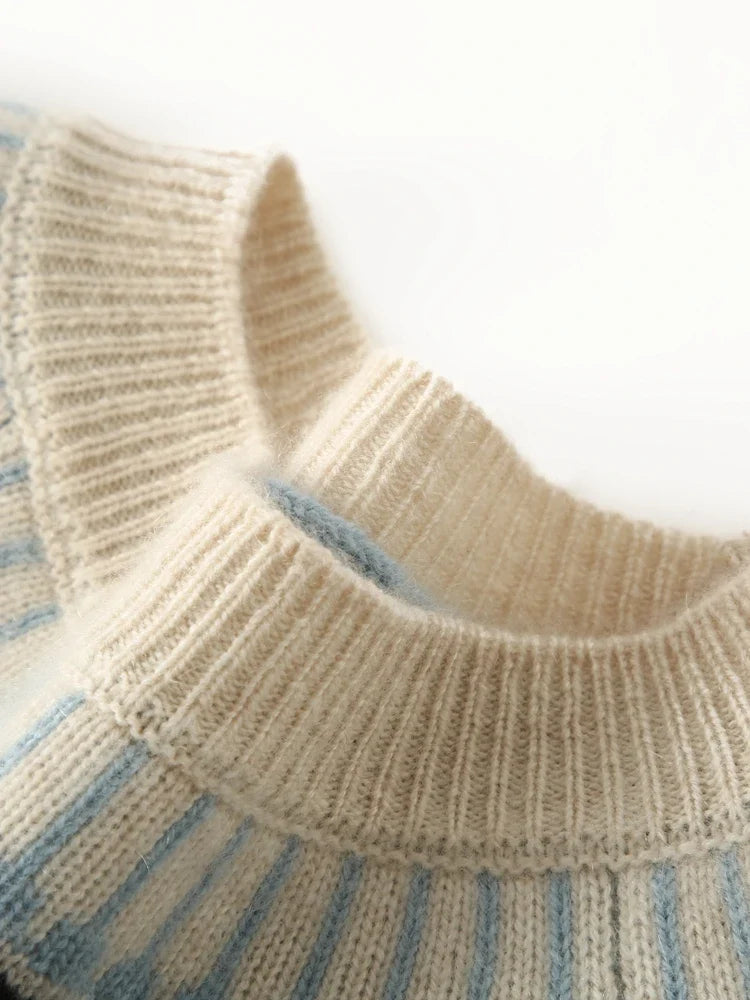 Cream-colored cashmere mock neck sweater for women by Christine Brewer, featuring a cozy, soft knit fabric and a fitted silhouette.