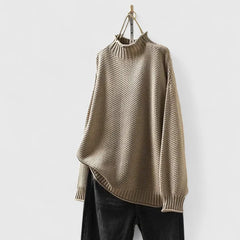 Woman wearing a beige knit sweater from the Harmony collection by Christine Brewer, featuring a cozy, stylish design.