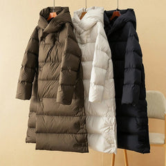 Long hooded women's parka by Christine Brewer featuring a sleek design and a cozy, insulated fit for cold weather.