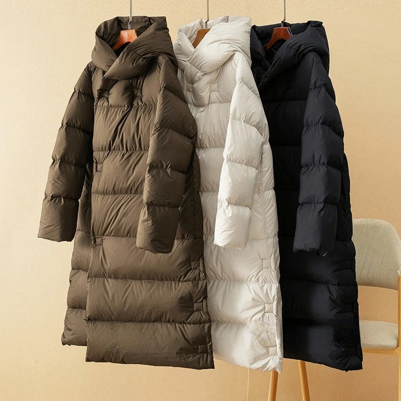 Long hooded women's parka by Christine Brewer featuring a sleek design and a cozy, insulated fit for cold weather.