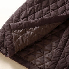 Christine Brewer Elena longline puffer jacket for women, stylish and warm, shown in a sleek black design with a high collar and quilted pattern.