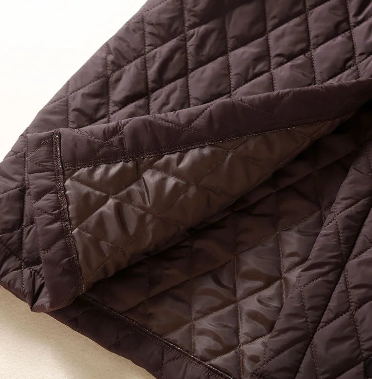 Christine Brewer Elena longline puffer jacket for women, stylish and warm, shown in a sleek black design with a high collar and quilted pattern.