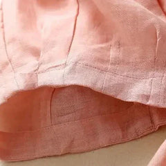 Women’s tapered linen trousers by Christine Brewer featuring loose, pull-on design and relaxed fit in natural linen fabric.