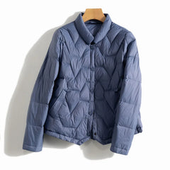 Women’s Aurora short quilted puffer jacket by Christine Brewer, with a snug fit and shiny quilted exterior.