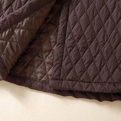 Longline puffer jacket for women by Christine Brewer, featuring a quilted design and hooded style in a sleek, insulated look.