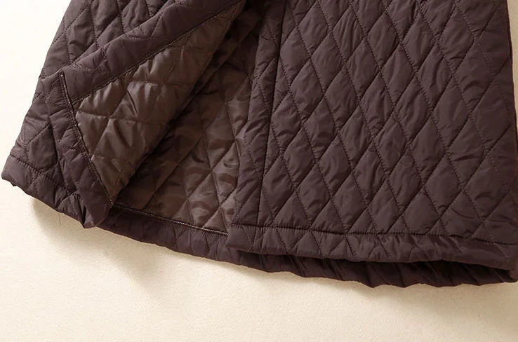 Longline puffer jacket for women by Christine Brewer, featuring a quilted design and hooded style in a sleek, insulated look.